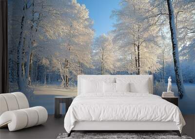 A serene winter landscape with snow-covered trees and a bright blue sky on a sunny day in a tranquil forest Wall mural