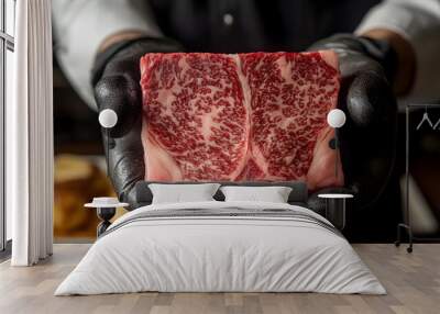 A chef's gloved hands hold a large, raw, marbled steak with a close-up view of the meat. Wall mural