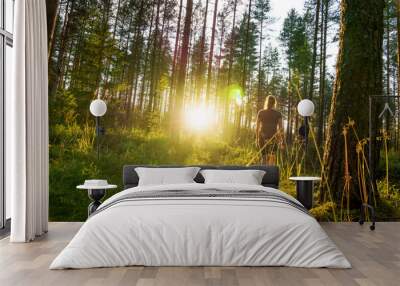 young woman walking in forest path at sunset. summer night in nature at dawn. carefree lifestyle. su Wall mural