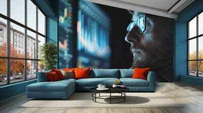 A man wearing glasses is looking at a computer screen with a lot of numbers Wall mural