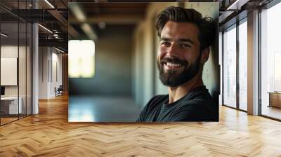 A man with a beard and a smile is standing in front of a wall Wall mural