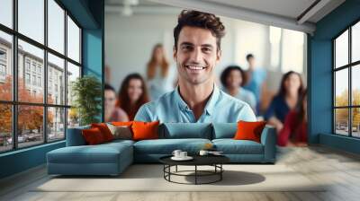 A man with a smile on his face is posing for a photo with a group of people Wall mural