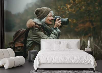 A woman with a camera is taking a picture in a field Wall mural