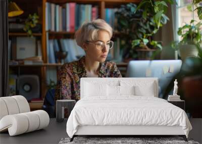 A woman with short hair and glasses is sitting at a table Wall mural