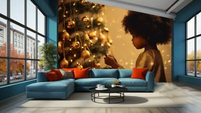 cute little girl with curly afro hair decorating the Christmas tree in the evening with a garland and balls Wall mural