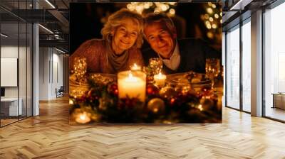 A mature couple is sitting at a table with candles and wine glasses celebrating Christmas. Warm and intimate scene Wall mural