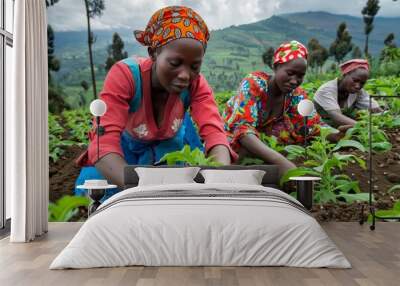 Three women are working in a field of plants. The women are wearing colorful clothing and are focused on their work Wall mural