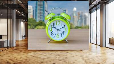 alarm green clock on table with green background. Wall mural