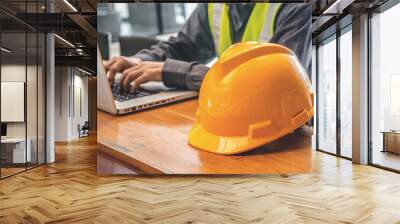 The yellow safety helmet and Business man in Construction industry is working in on computer on the background. Wall mural