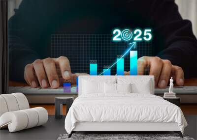 2025 business growth, digital market, investment and technology concept. 2025 calendar number with target icon on hologram graph, forecasting analysis diagram while businessman working with computer. Wall mural