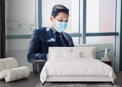 Asian businessman in suit wearing protective face mask. Wall mural