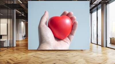 Red heart. Big red heart ball in hand on grey background. Wall mural