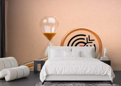 Short-term business goals encompass work that helps an organization reach its mid-term goals concept. Big target icon in gold magnifying glass lens near hourglass isolated on beige background. Wall mural