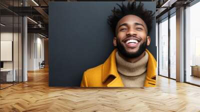 A smiling young man dressed in a stylish coat enjoys a moment of joy in an urban environment Wall mural