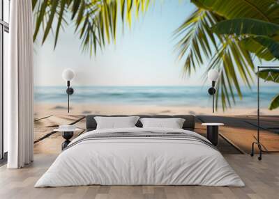 Empty wooden tabletop against the background of the blue sea, beach and palm leaves on a summer day. Background with copy space for product display. Wall mural