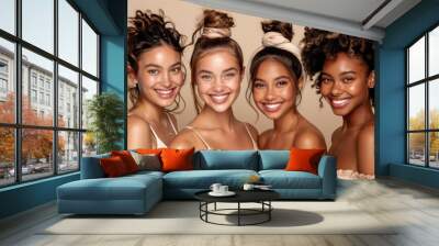 Four diverse women with bright smiles pose together in a studio portrait, showcasing natural beauty Wall mural