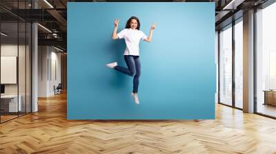 Full body photo of young cheerful girl jumper show fingers peace cool v-symbol isolated over blue color background Wall mural