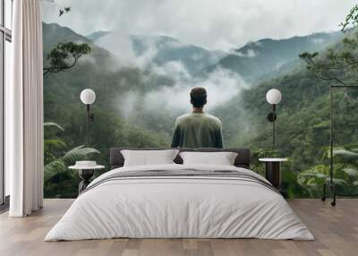 Generated with AI back view photo of man sitting alone on the mountain top and looking beautiful view Wall mural