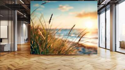 Golden sunset colors the coastal grass as waves gently lap at the shore at dusk Wall mural