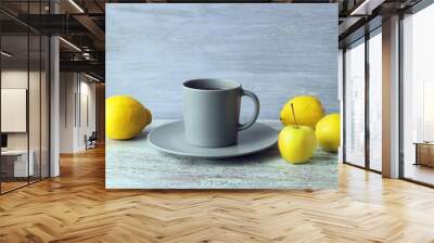 Hot tea in a large cup, lemons and apples on a wooden windowsill, the concept of a vitamin drink for colds, home comfort Wall mural