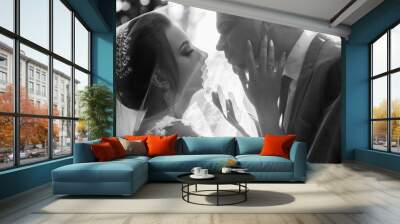 Wedding couple kisses under the veil. The Kiss. Close up portrait of sexy stylish wedding couple kissing under white veil. Portrait of lovers. The couple fully enjoys the moment. Black and white Wall mural