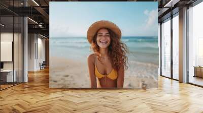 Portrait of beautiful woman wearing straw hat at beach and looking at camera. Closeup face of attractive smiling girl with freckles and red hair. Wall mural