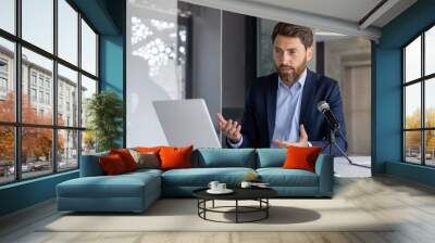 Professional man recording a podcast with a microphone and laptop Wall mural