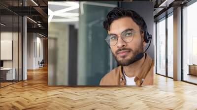 Smiling customer service representative with headset in a modern office Wall mural