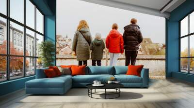 Back view of mother with children looking at city and sea from the hill. Local travel in native town concept. Wall mural