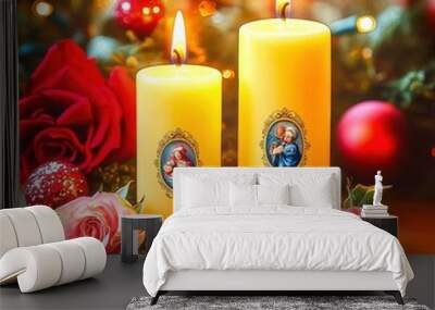 Two lit candles with religious figures celebrating christmas with roses and lights in background Wall mural