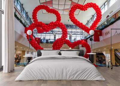 Valentine's day decor red balloons in the shape of hearts in shopping mall hanging from the ceiling. Love Day Celebration Wall mural