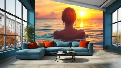 Woman relaxing during sunset time at sea with orange sky Wall mural