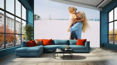 Young mother and happy little son at sandy beach in Dubai, UAE Wall mural