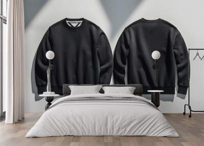 A black sweatshirt displayed from the front and back on a light background with shadows. Wall mural