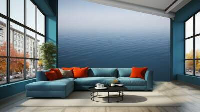 A serene view of calm water with gentle ripples, reflecting a soft blue hue. The surface appears smooth and tranquil, creating a peaceful atmosphere. Wall mural