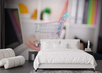 businessman with miniature shopping cart in the office, shopping and sales concept Wall mural