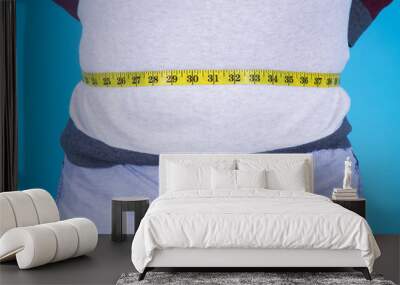 man circling belly with tape measure, diet concept Wall mural