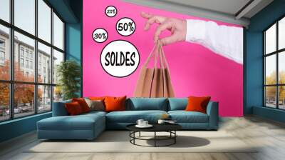 man with bags in hand with sale and discounts text, concept of shopping and sales Wall mural