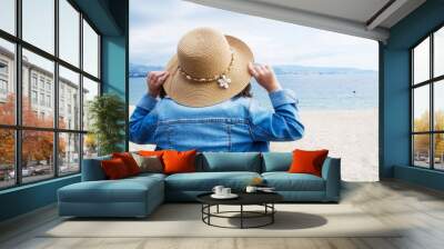 portrait of girl in hat looking out to sea Wall mural