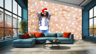 young woman with santa claus hat and snowflakes Wall mural