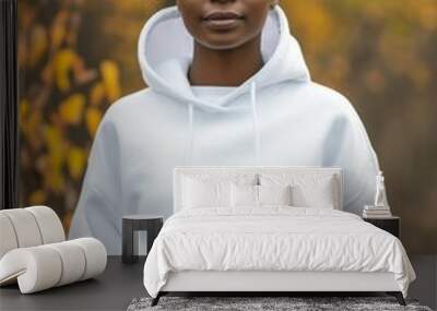 Young black woman wearing a white sweater with hood in autumn. White hoodie mockup. Wall mural