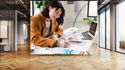 Architecture and interior design concept. Young businesswoman architect choosing materials and details for creating interior design project in studio. Freelancer woman working in a modern office Wall mural