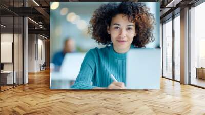 Focused woman working on laptop at modern office. Professional and confident, she exemplifies productivity and dedication in a corporate environment. Wall mural