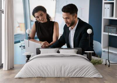 We both can work, but together we will win. two young business colleagues sitting together and using a laptop in the office. Wall mural