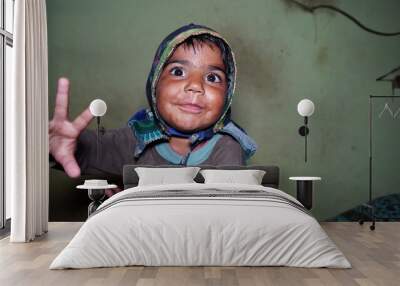 Cheerful little kid wearing hat on head and smiling at camera. Little kid showing white teeth. Wall mural