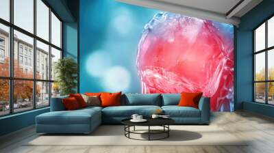 Close-up of ice melting with vibrant red liquid, creating a captivating visual contrast on a soft blue background. Wall mural