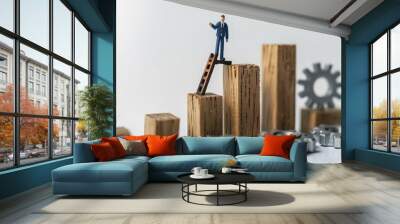 A businessman at the top of a ladder representing business success A line graph indicating growth in corporate objectives Wooden blocks with an upward arrow and growth chart Wall mural