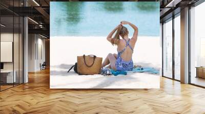 Blonde tourist girl in bikini relaxed and sunbathing on the beach Wall mural