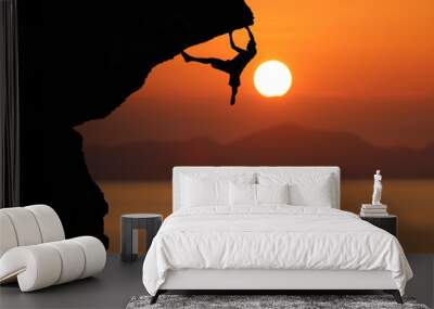 Silhouette of climber on a cliff against beautiful red sky sunset Wall mural