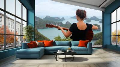 Woman playing acustic guitar on the top of the mountain. The view point of Ang thong island.Thailand  Wall mural